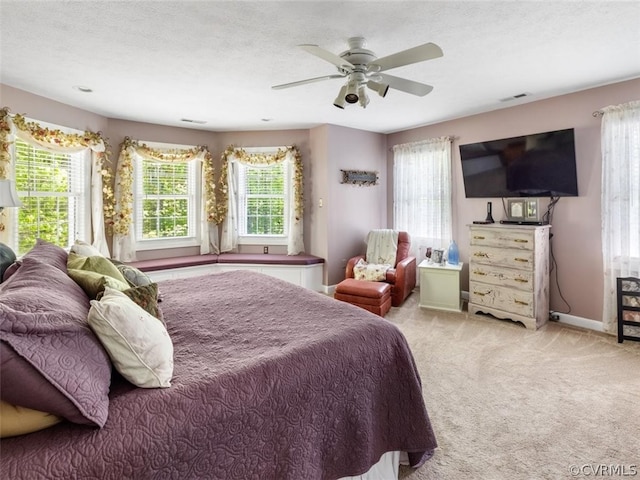 carpeted bedroom with ceiling fan and a textured ceiling