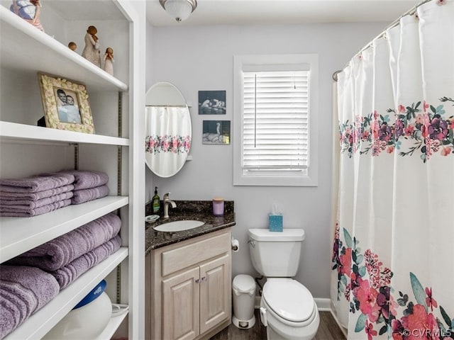 bathroom featuring wood-type flooring, vanity, and toilet