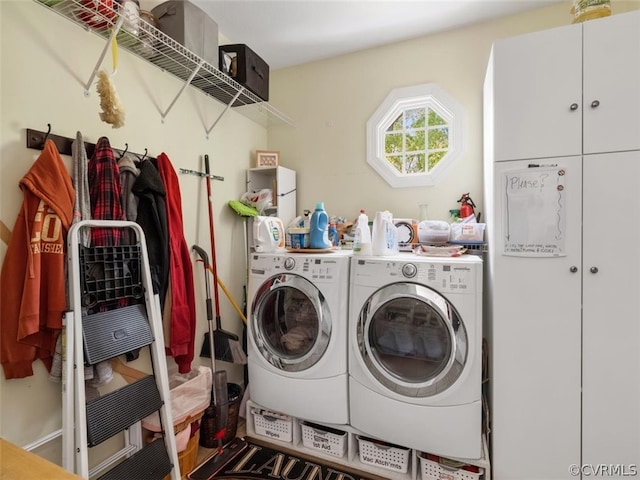 washroom with washer and clothes dryer and cabinets