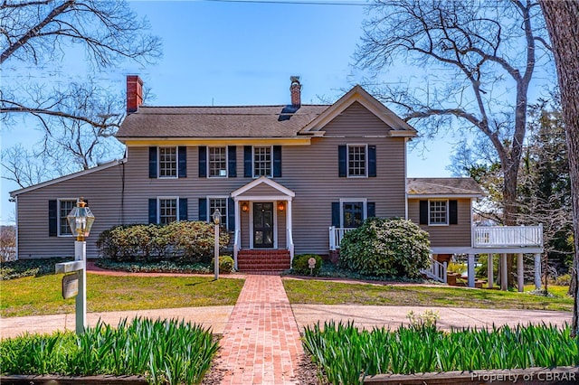 colonial inspired home with a front lawn