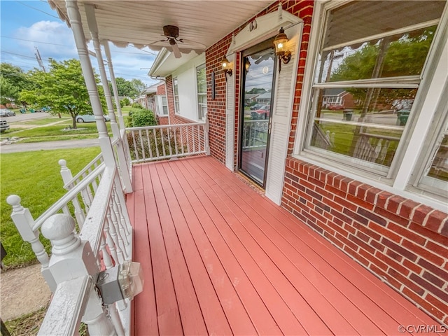 wooden deck with a yard and ceiling fan