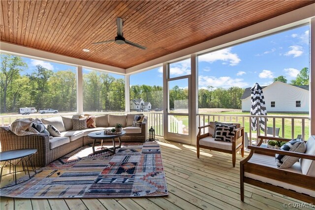 sunroom with plenty of natural light, ceiling fan, and wooden ceiling