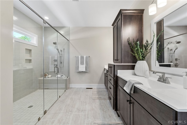 bathroom with walk in shower, vanity, and tile floors