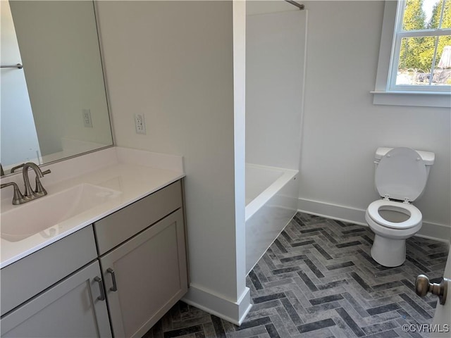 bathroom with toilet, baseboards, and vanity