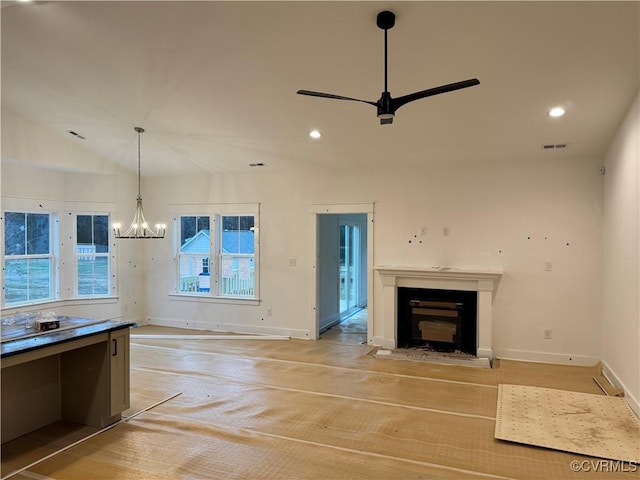 unfurnished living room with recessed lighting, visible vents, a fireplace, and ceiling fan with notable chandelier