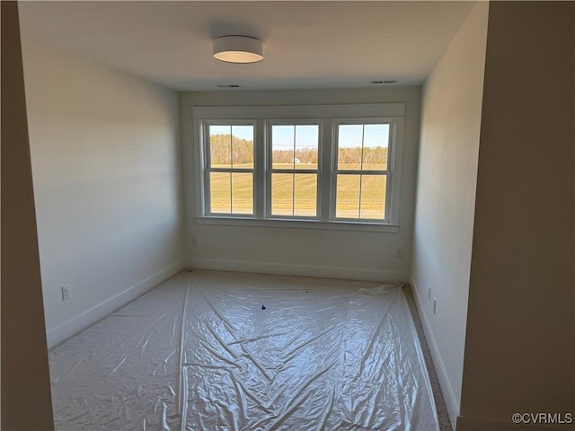 empty room with visible vents, plenty of natural light, and baseboards