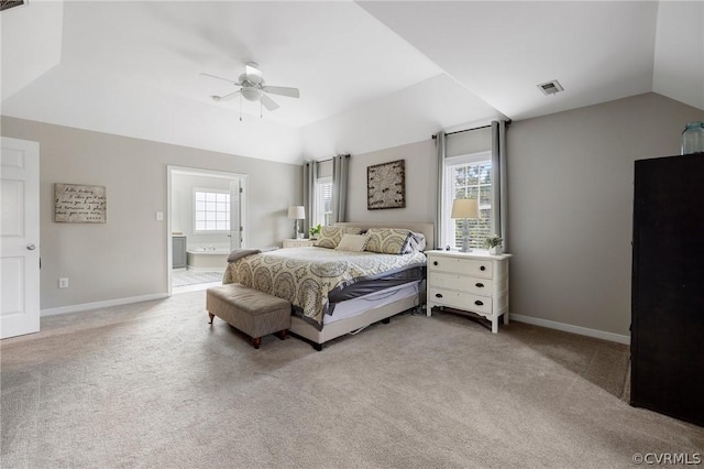 carpeted bedroom with multiple windows, connected bathroom, vaulted ceiling, and ceiling fan