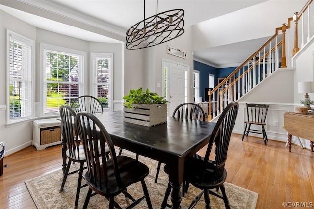 dining room with crown molding and light hardwood / wood-style floors