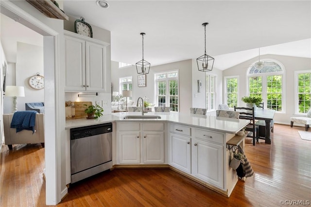 kitchen with pendant lighting, sink, white cabinetry, vaulted ceiling, and stainless steel dishwasher