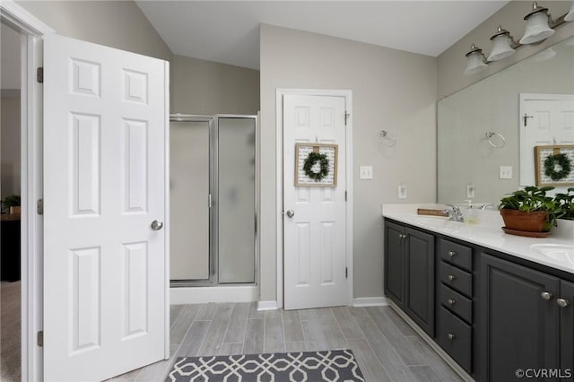 bathroom featuring vanity, lofted ceiling, and an enclosed shower