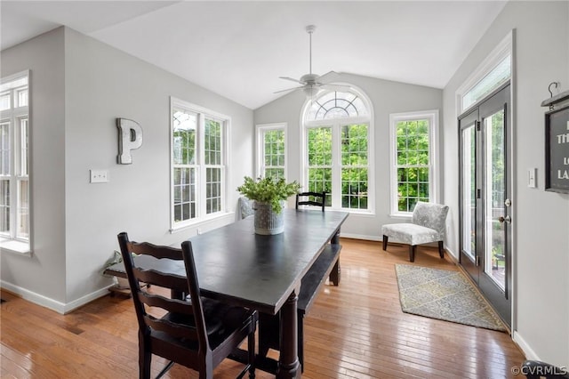 dining space featuring ceiling fan, light hardwood / wood-style flooring, plenty of natural light, and vaulted ceiling