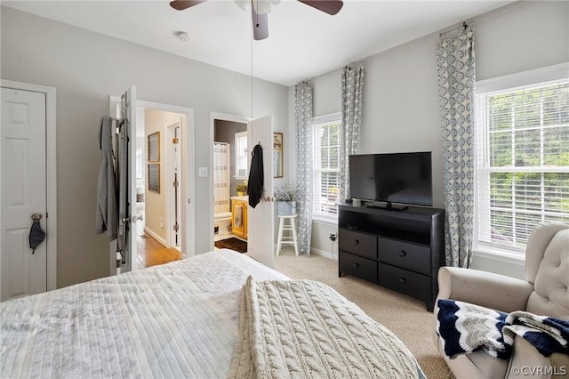 carpeted bedroom featuring connected bathroom and ceiling fan