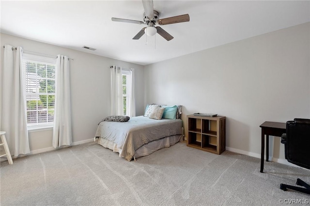 carpeted bedroom with multiple windows and ceiling fan