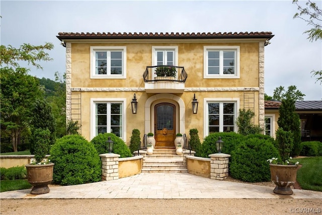 mediterranean / spanish home with french doors and a balcony