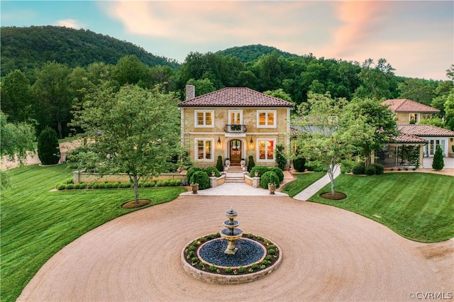 mediterranean / spanish house featuring a mountain view and a yard