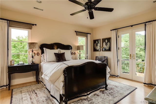 bedroom with light hardwood / wood-style flooring, multiple windows, french doors, and access to exterior