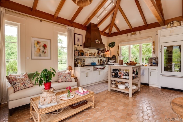 living room with a healthy amount of sunlight, tile flooring, high vaulted ceiling, and beam ceiling