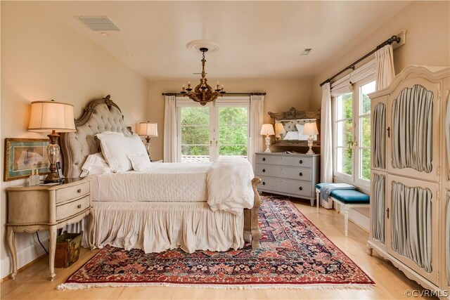 bedroom featuring a chandelier and light wood-type flooring