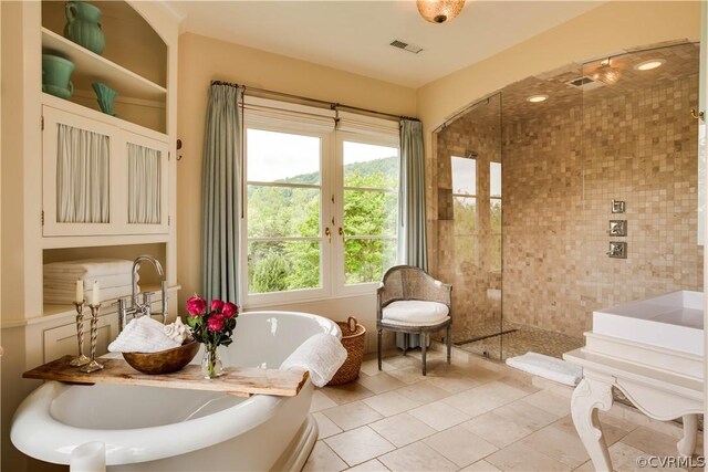 bathroom featuring tile floors and separate shower and tub