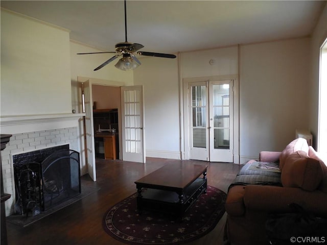 living room with ceiling fan, dark wood-type flooring, french doors, and a fireplace