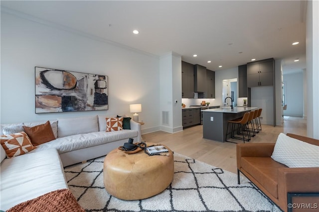 living room with recessed lighting, visible vents, baseboards, and light wood-style flooring