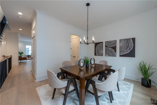 dining room featuring light wood-type flooring, baseboards, an inviting chandelier, and ornamental molding