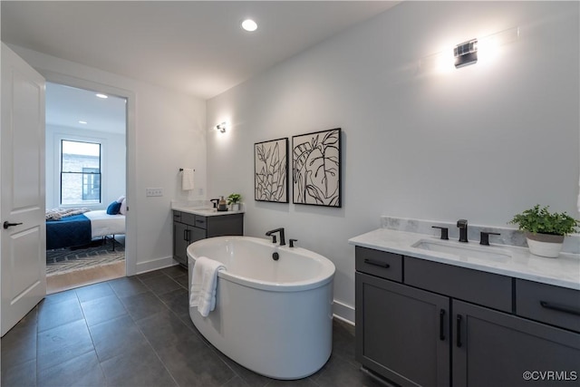 ensuite bathroom featuring vanity, baseboards, a freestanding bath, tile patterned flooring, and connected bathroom