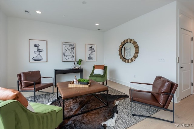 living area with recessed lighting, visible vents, light wood-style flooring, and baseboards