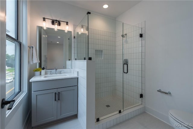 bathroom featuring a shower stall, baseboards, toilet, tile patterned floors, and vanity