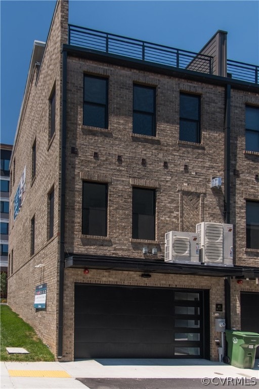 view of front of property featuring cooling unit and a garage