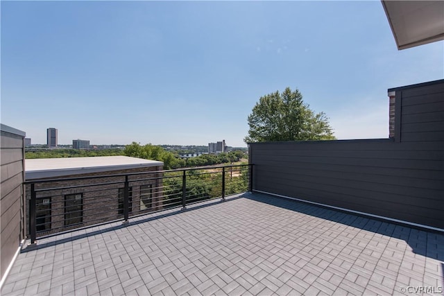 view of patio / terrace with a view of city and a balcony