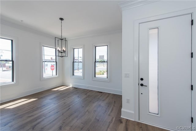 unfurnished dining area featuring visible vents, baseboards, dark wood finished floors, ornamental molding, and a notable chandelier