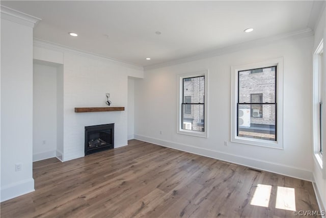 unfurnished living room featuring crown molding, wood finished floors, a fireplace, and baseboards