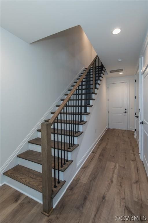 stairway with recessed lighting, wood finished floors, and baseboards