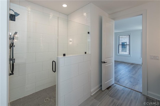 full bath with a shower stall, baseboards, and wood tiled floor