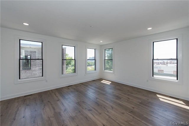 spare room with dark wood finished floors, visible vents, recessed lighting, and baseboards