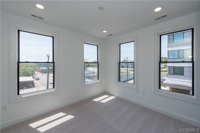 carpeted spare room with recessed lighting, visible vents, and baseboards