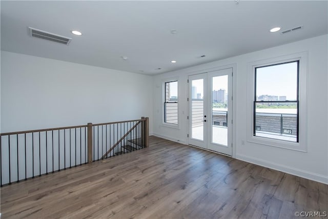 spare room featuring recessed lighting, visible vents, wood finished floors, and french doors