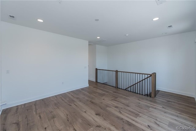 unfurnished room with recessed lighting, baseboards, and wood finished floors