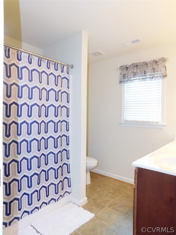 bathroom with tile flooring, vanity, and toilet