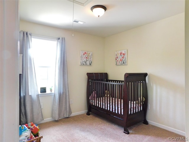 carpeted bedroom featuring a nursery area and multiple windows