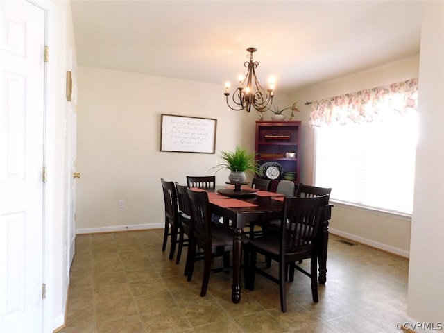 dining area featuring tile flooring and an inviting chandelier