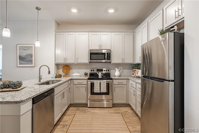 kitchen featuring white cabinetry, sink, pendant lighting, and appliances with stainless steel finishes