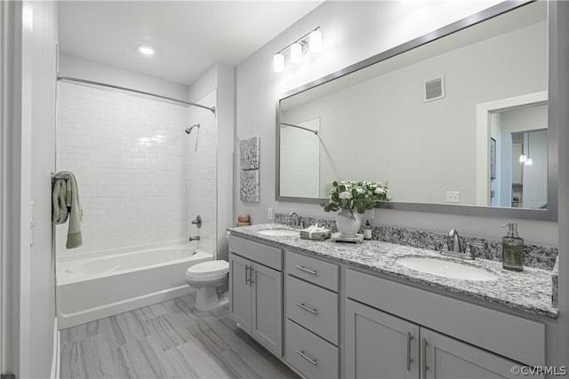 full bathroom featuring vanity, toilet, and tiled shower / bath