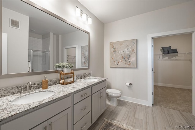 bathroom with vanity, toilet, and an enclosed shower