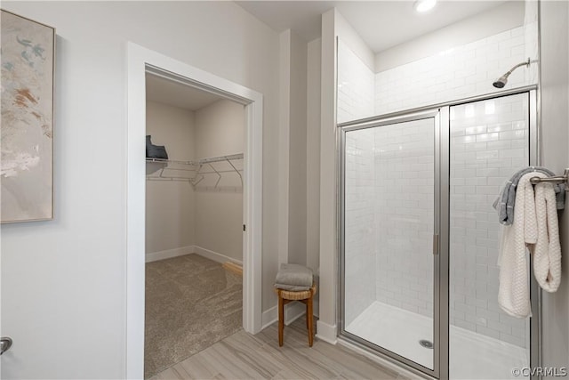 bathroom with a shower with shower door and hardwood / wood-style flooring