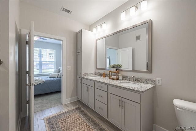 bathroom with hardwood / wood-style floors, vanity, and toilet