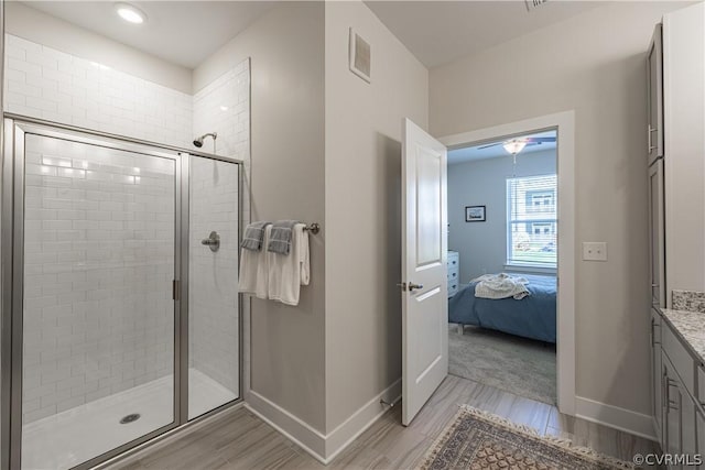 bathroom featuring vanity, wood-type flooring, and a shower with shower door