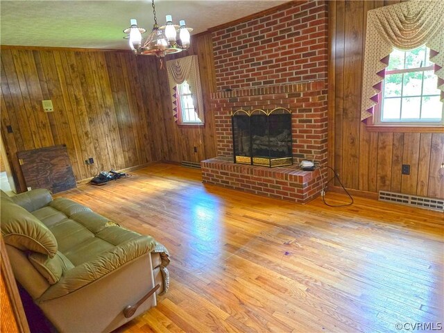 living room with plenty of natural light, wood walls, and hardwood / wood-style flooring