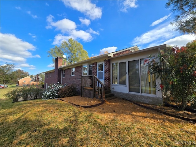 rear view of property featuring a lawn